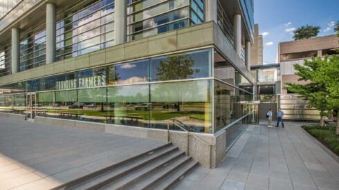 an office building with people walking in front of it
