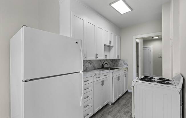 a kitchen with white cabinets and white appliances at Stockbridge Apartment Homes, Seattle, Washington 98101