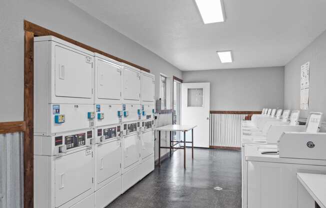 a room with white cabinets and a table with a laptop on it