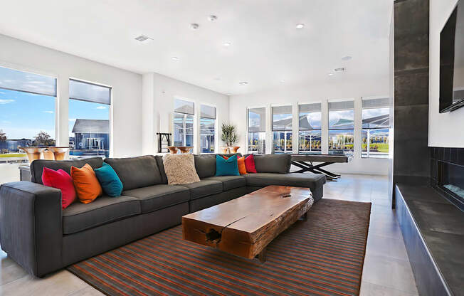 A modern living room with a grey couch and a wooden coffee table.