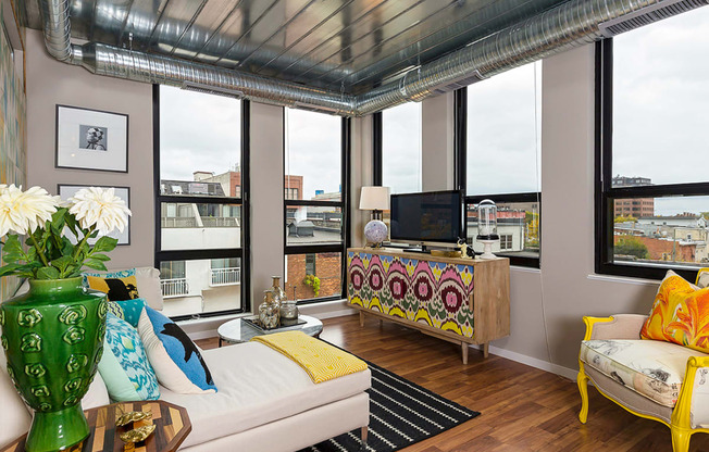 a living room with a view of the city and a couch and a television at Ann Arbor City Club, Ann Arbor, 48104