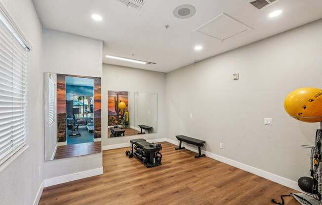 A room with a wooden floor and a wall with a picture of a sunset.