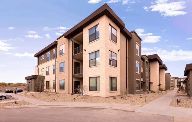 A row of modern apartment buildings with a clear blue sky above.