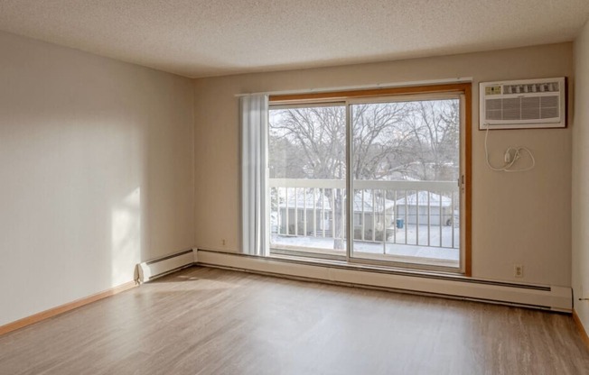 the living room of an empty house with a large window