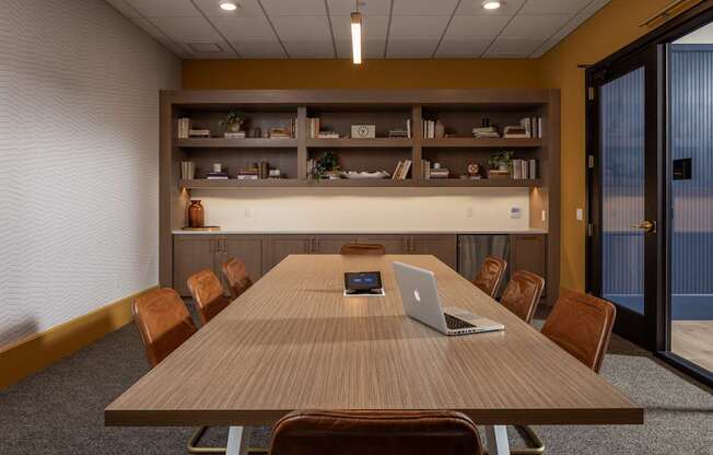 A conference room with a long table and chairs.