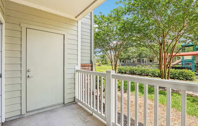 A Royal Palm fenced in patio looks out at the lush greenery at Oakleaf Plantation Apartments in Jacksonville, FL