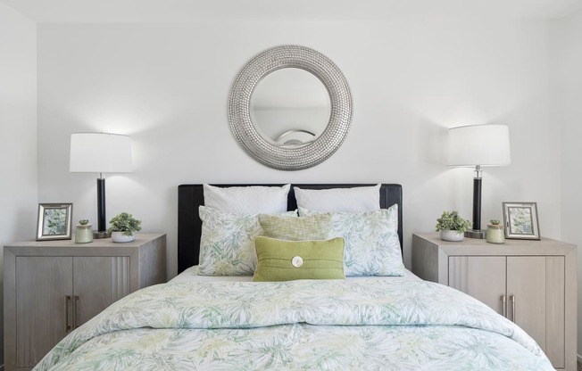 a bedroom with a bed with a green and white comforter and pillows