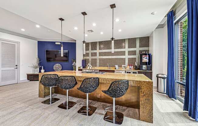 Sleek catering kitchen with a large island and bar seating at Allusion at West University apartments in Houston, TX.