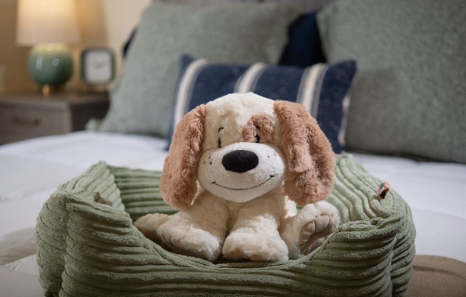 a stuffed dog is sitting on a bed