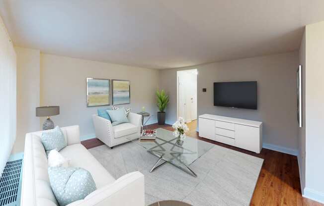 a living room with couches and a glass coffee table and a tv at penn view apartments in washington dc