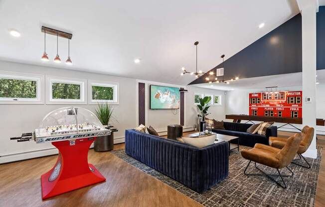 A modern living room with a red table and a blue sofa.