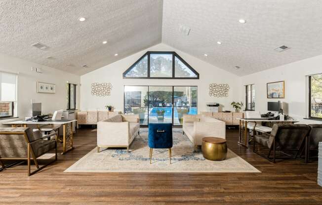 a living room with a vaulted ceiling and a view of a pool