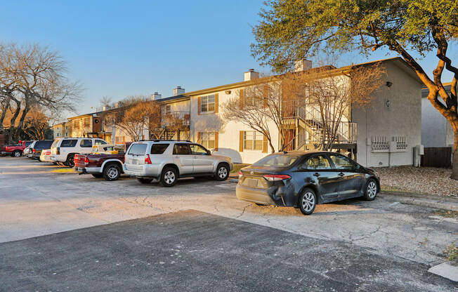 A parking lot with cars and apartment buildings in the background.