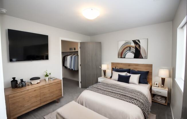 A bedroom with a large bed and a wooden dresser.