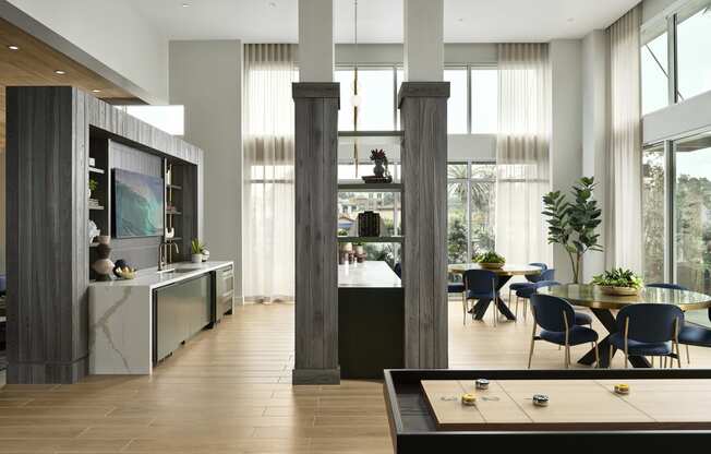 the living room and dining area of a modern house with large windows