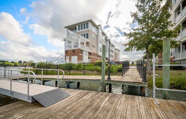 A wooden walkway leads to a building with a white and red facade.