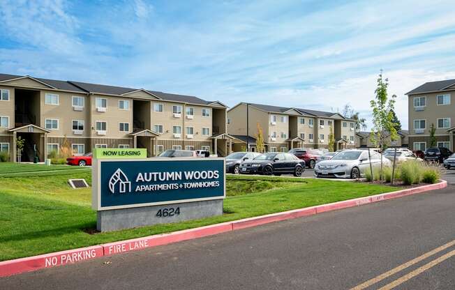 an exterior view of an apartment complex with cars in the parking lot