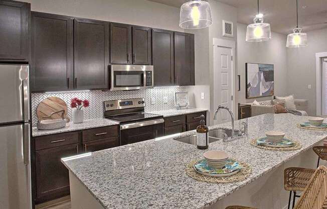 a kitchen with stainless steel appliances and a granite counter top at Hunters Creek Apartments, Texas, 76210