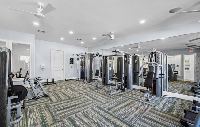 A gym with a variety of equipment including treadmills, weights, and exercise machines.