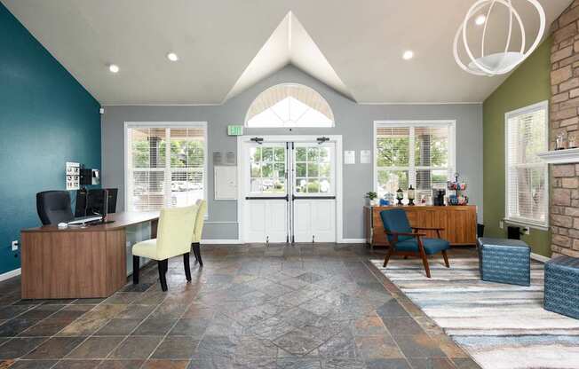 a reception area with a desk and chairs and a glass door