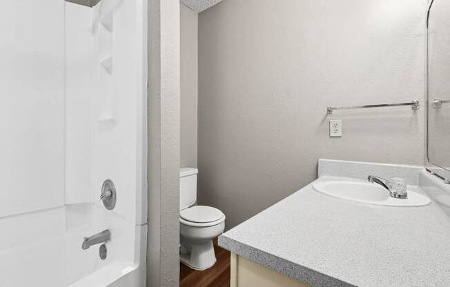 A white bathroom with a toilet, sink, and bathtub.
