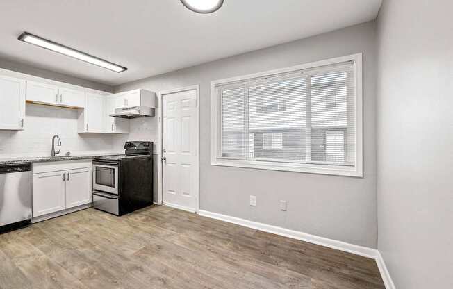A kitchen with a stove, oven, and sink.
