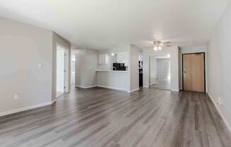 A spacious room with wooden flooring and a ceiling fan.