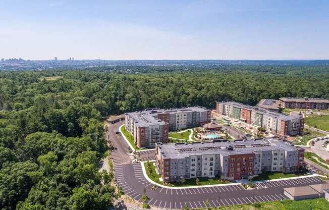 an aerial view of an apartment complex with trees and a parking lot