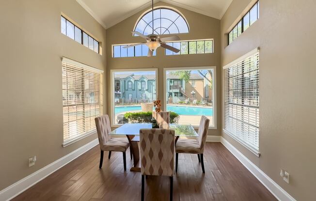 a dining room with a large window and a table with chairs