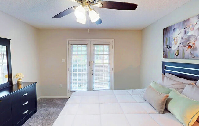 A bedroom with a bed, dresser, and a painting on the wall.