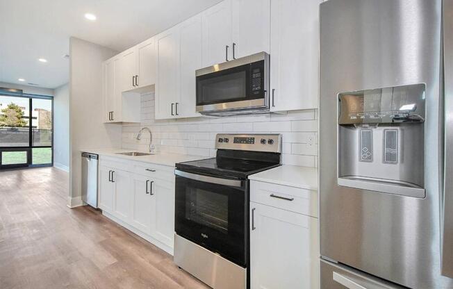 A modern kitchen with stainless steel appliances and white cabinets.