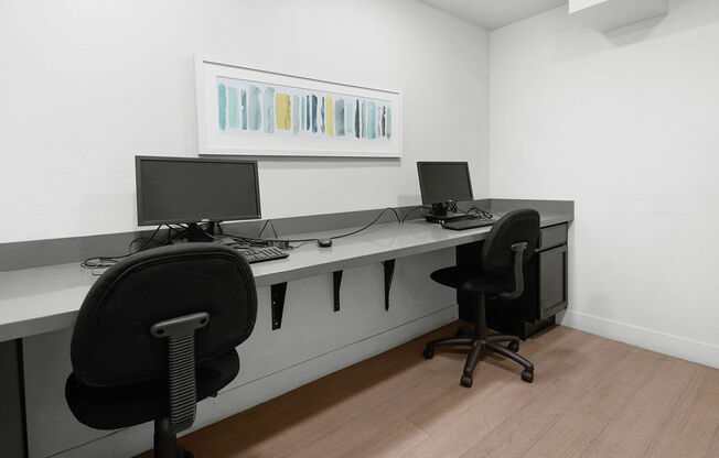 a desk with two computers on it in a room