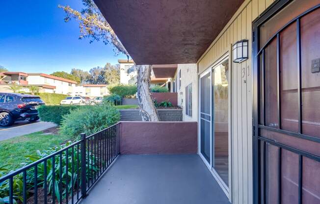 a balcony with a door and a street in the background