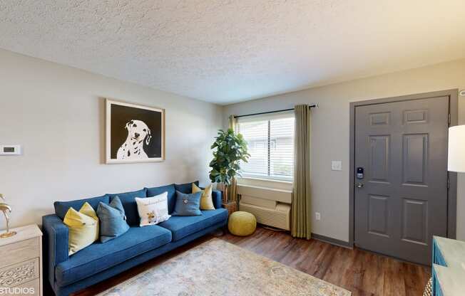 a living room with a blue couch and a grey door