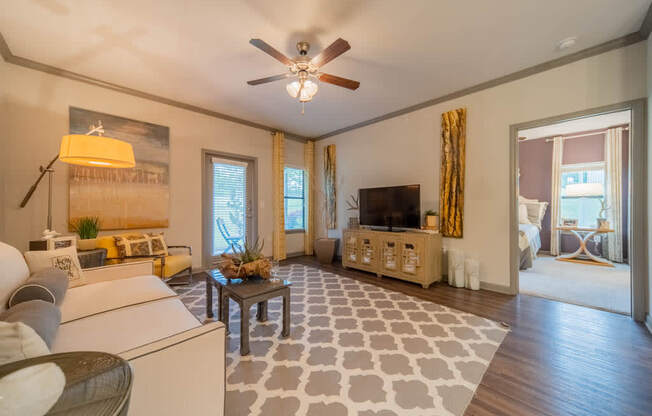 a living room filled with furniture and a ceiling fan