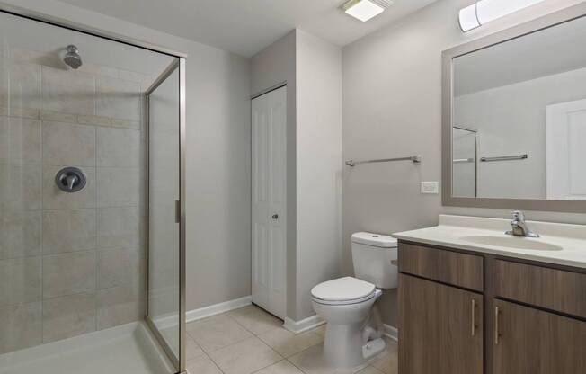 A bathroom with a toilet, sink, and shower.
