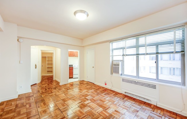 vacant living area with hardwood flooring and large windows at baystate apartments in washington dc