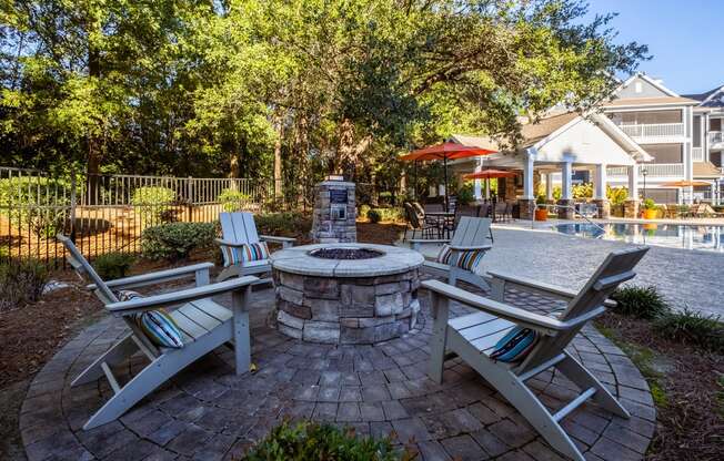 a patio with chairs and a fire pit and a pool