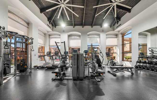 A gym with a variety of equipment including treadmills, stationary bikes, and weight machines.