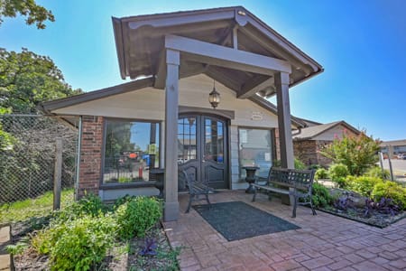 A small house with a porch and a fence.