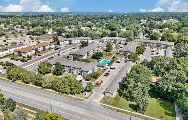 A bird's eye view of a suburban area with roads, cars, and buildings.