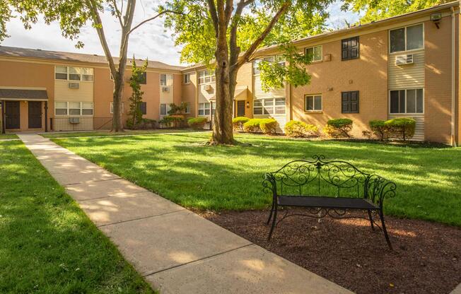an empty park bench sitting in front of a brick building