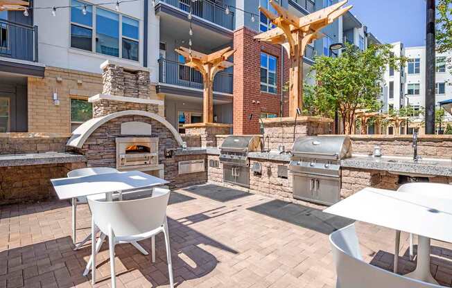 A patio with a table, chairs and a fireplace.