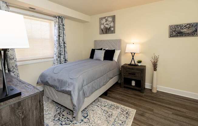 A second bedroom with a bed, nightstand, and lamp.