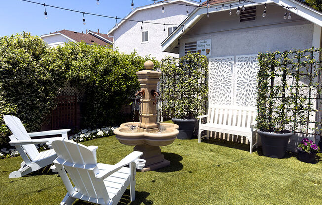 Outdoor seating and fountain in resident garden area.