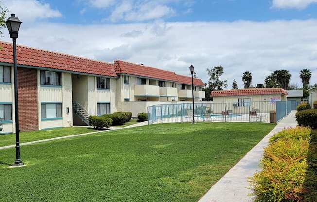 Gated swimming pool and grassy courtyard at Magnolia Apartments in Riverside, California.