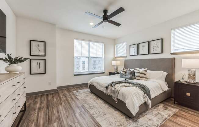 the master bedroom in a new home with a large bed and a ceiling fan at Meridian at CityPlace, Woodbury Minnesota