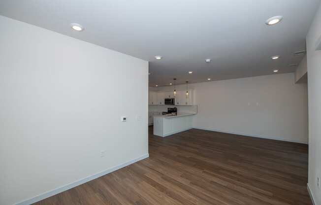 a living room and kitchen with white walls and wood flooring at The Crossings at Windsong, Prescott Valley