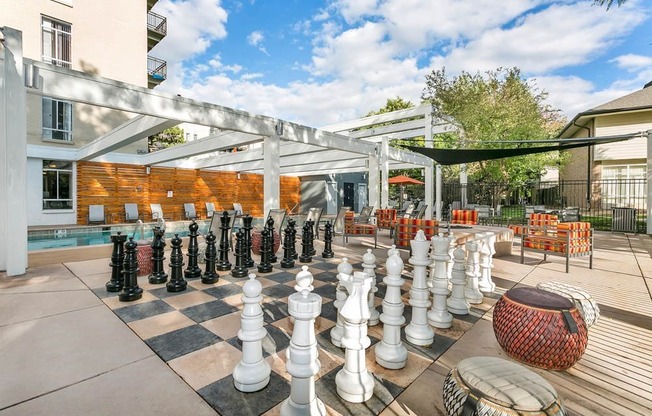 A giant chess set is set up on a patio.