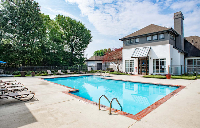 a swimming pool with lounge chairs and a building in the background at Lincoln at Wolfchase, Cordova, TN 38016